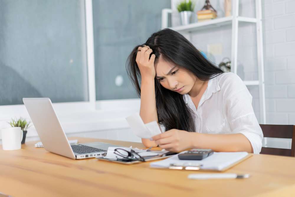 Woman trying to figure out bills, like how much electricity does an air purifier use?