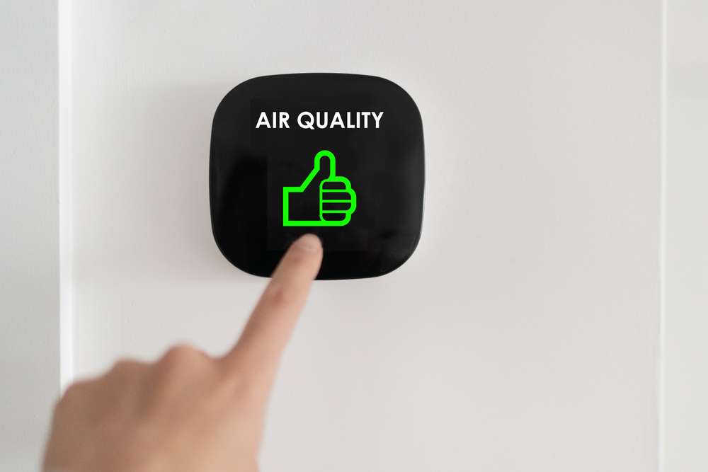 A hand pointing at an electronic sensor that says "Air Quality" and has a green thumbs up.