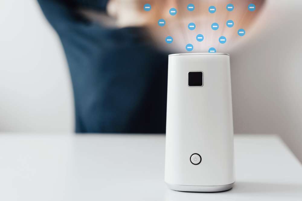 Closeup of small air purifier with graphic showing negative ions going into the air.