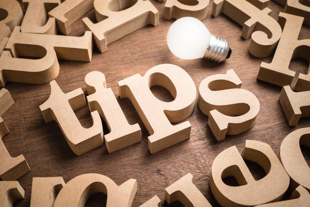 Wooden letters spelling out tips with a lightbulb illuminating them.