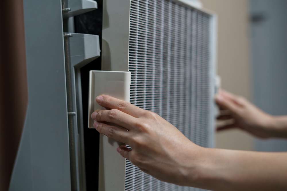 Person taking off a dirty HEPA filter.